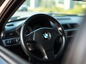 Mechanik wymienia oponę przy aucie za pomocą mobilnej wulkanizacji, w tle biały van serwisowy na miejskiej ulicy.