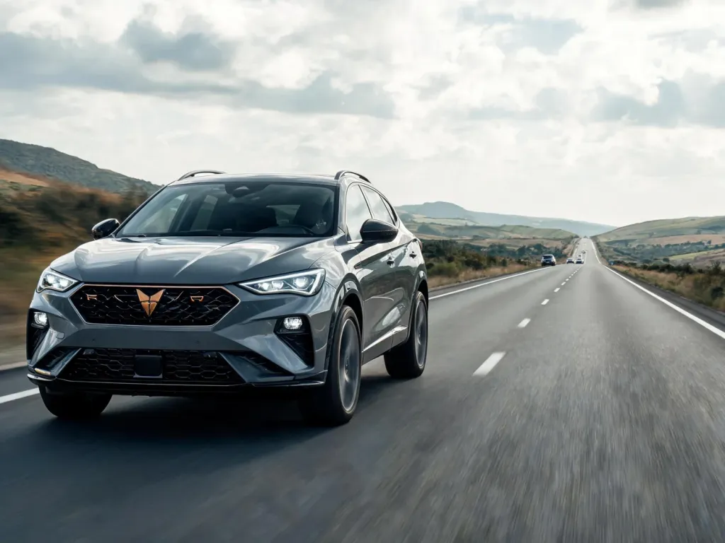 Cupra Formentor jedzie pustą drogą, nowoczesny SUV w ruchu na trasie, sugeruje realne spalanie w warunkach drogowych.